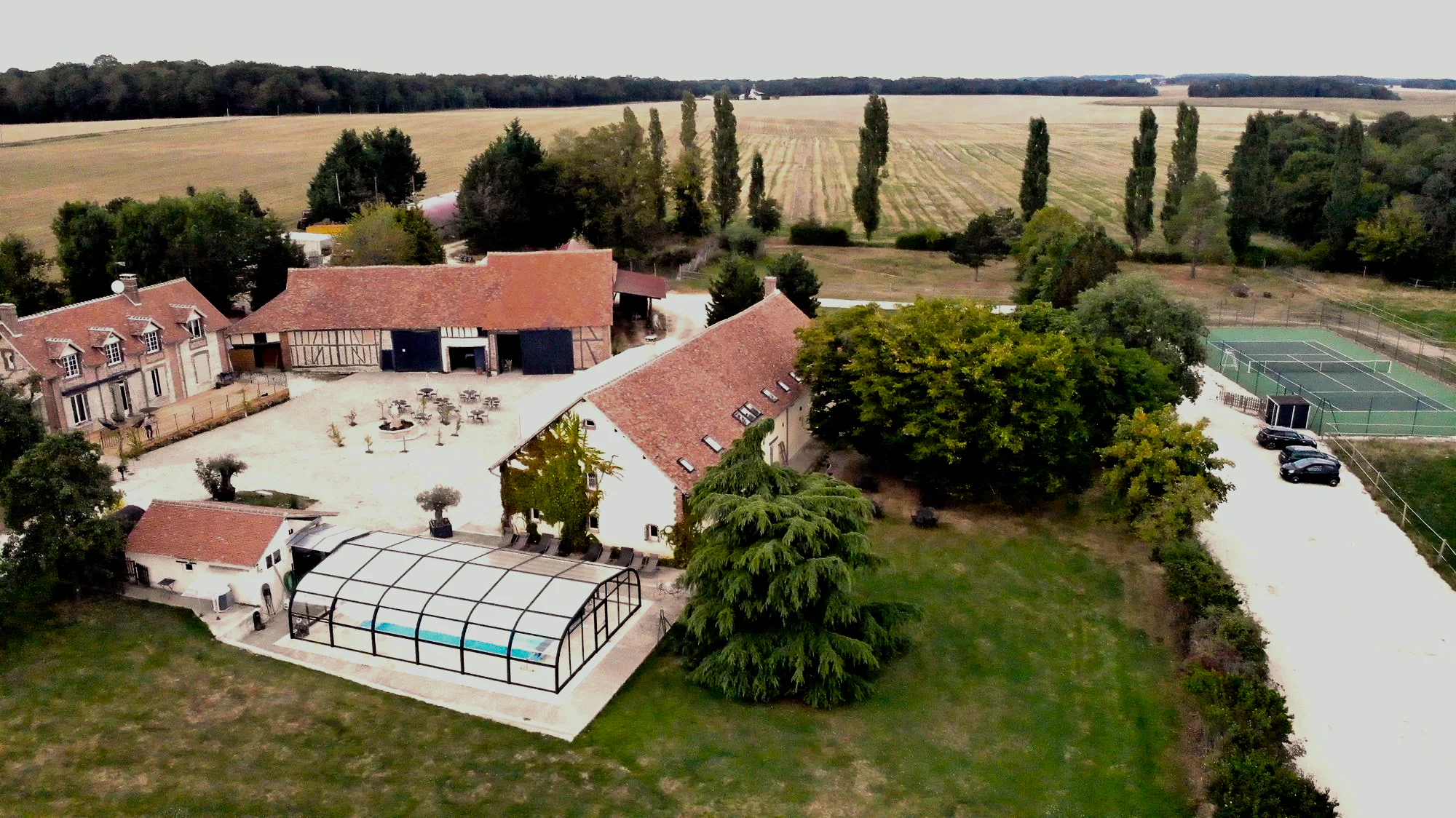 Vue aérienne du domaine : la cour, la piscine couverte et le tennis