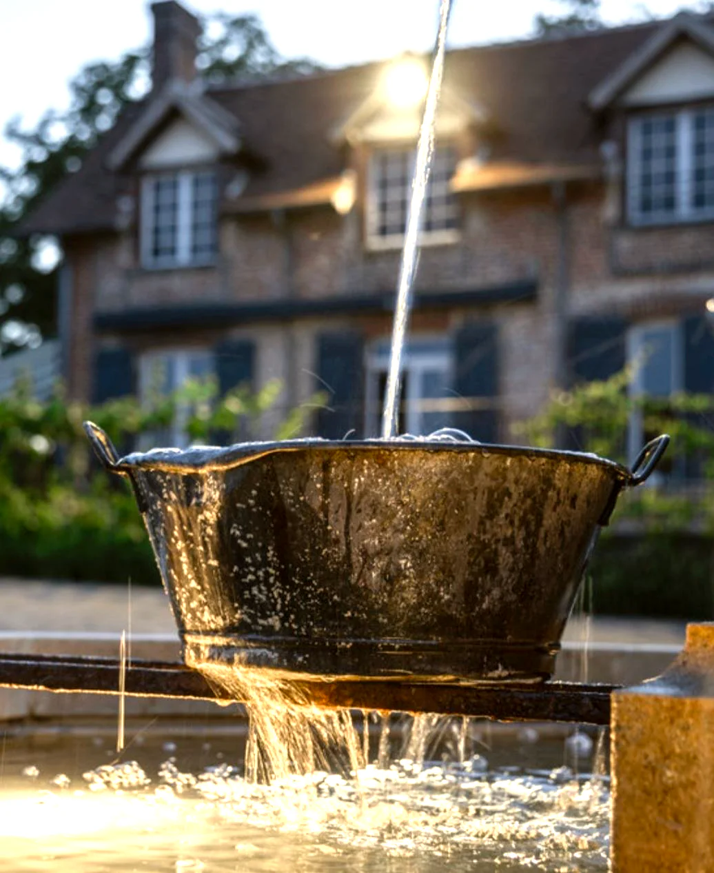 Le seau de la fontaine de la cour sous le jet d'eau