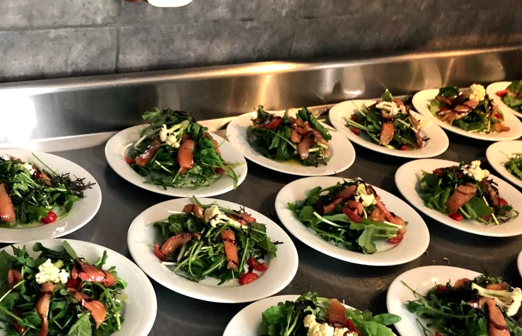 Des assiettes de salade alignées, prêtes à servir